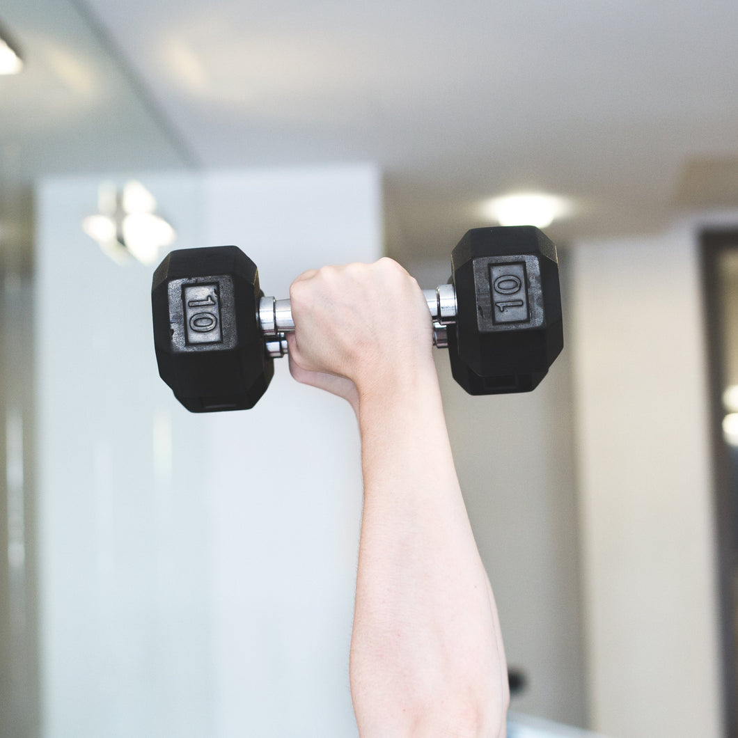 A close up of hands lifting dumbbells in the air.